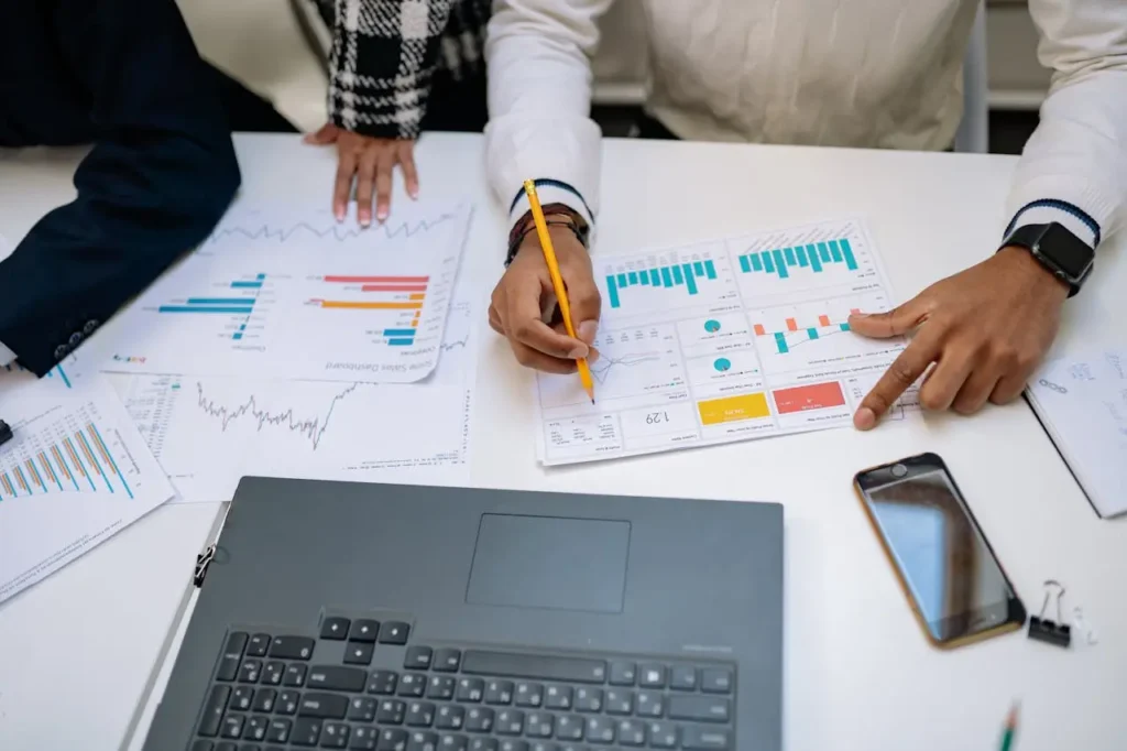 Empresaria revisando documentos financieros y gráficos en una oficina moderna.